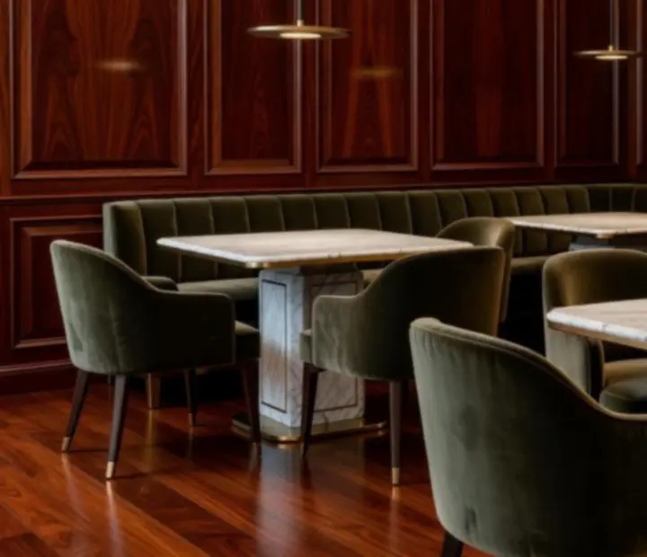 Interiores del restaurante con madera caoba, mármol y luz dorada envolvente.